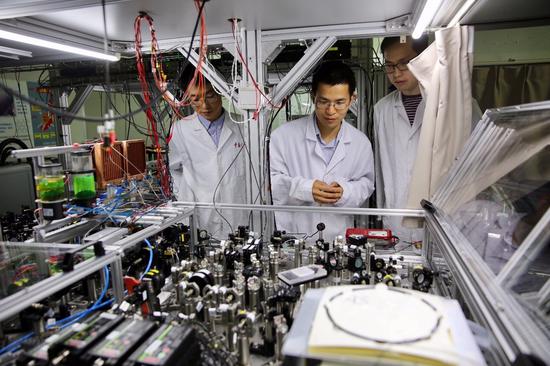  5月3日，中国科学技术大学陆朝阳教授（中）和学生们在中科院量子信息和量子科技创新研究院上海实验室检查光量子计算机的运行情况。新华社记者 金立旺 摄