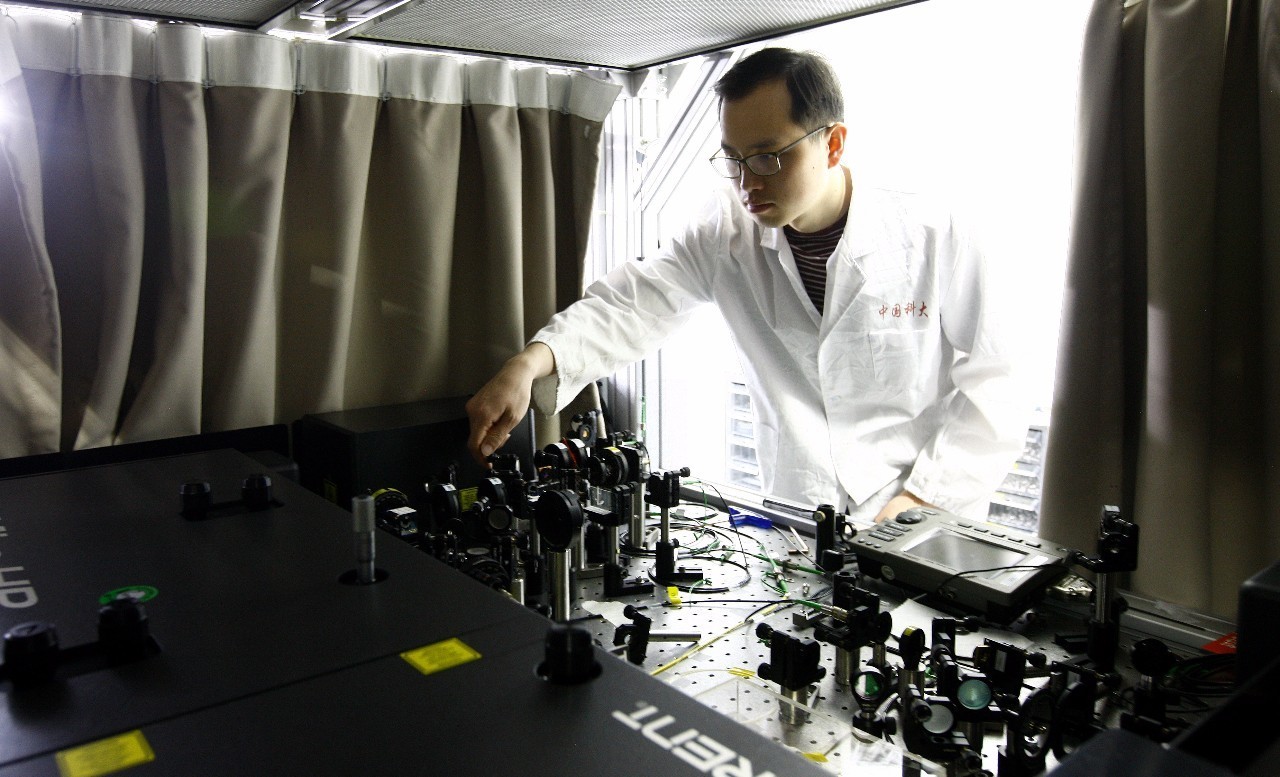  5月3日，一名科研人员在中科院量子信息和量子科技创新研究院上海实验室内调整操作台上的激光干扰器。新华社记者 方喆 摄
